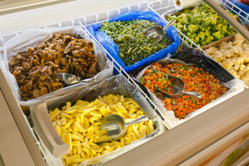 Frozen vegetables in the refrigerator of the store.