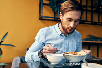 Fototapeta na wymiar business man in blue shirt having lunch at a cafe table