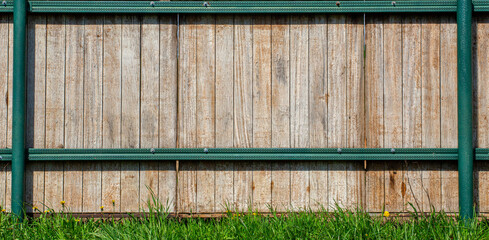 Wooden gate as a background. Old wood in a green frame. Gate to the paddock. On a farm
