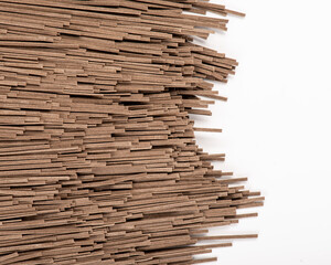 Raw whole grain brown spaghetti isolated on white background. Raw ramen noodles. Photo for site.