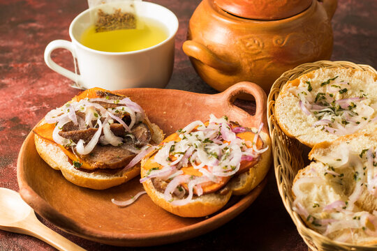 Desayuno sabroso, sandwich de chancho en vajilla artesanal con infusi&oacute;n de an&iacute;s caliente