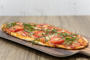 Margarita flatbread pizza topped with slices of tomato, cheese on delicious baked flatbread crust