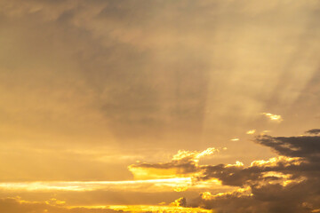 Golden hour sun rays at sunset with thin clouds