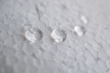 cuatro gotas de agua limpia sobre fondo blanco desenfocado