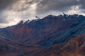 Fototapeta na wymiar dramatic autumn landscape of snowcapped mountain ranges and peaks inside DEnali National park .