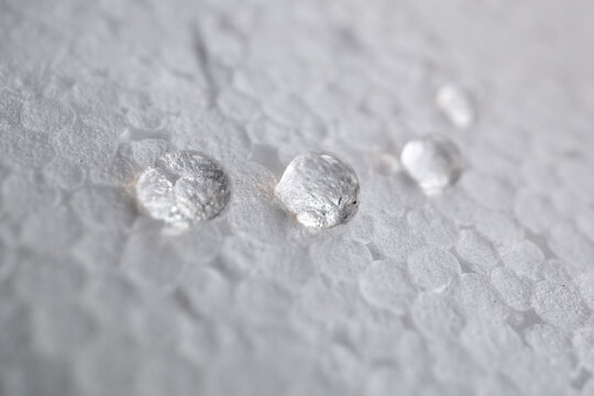 cuatro gotas de agua limpia sobre fondo blanco desenfocado