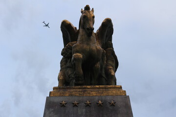 Horse statue with plane in background