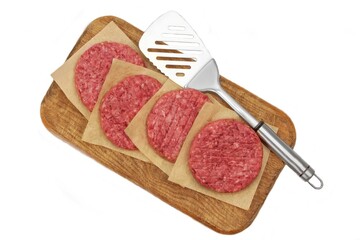 Minced Raw Steak Burgers from Beef Pork Meat on Cutting Board Isolated on White Background, Overhead View. Uncooked Ground Meat Patties for Grilling. Burgers for BBQ Grill and Spatula, Top View.