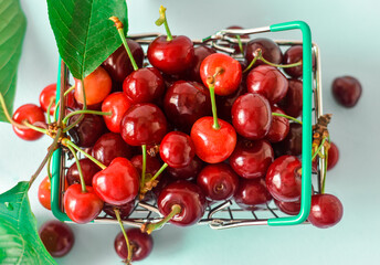 Fresh cherries in shopping wheel basket. Top view.
