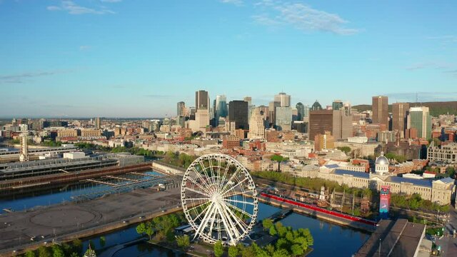Aerial Drone of Downtown Montreal  on Sunny Day. Camera Reverses Showing the Ferris Wheel and Old Port of the City Centre in Quebec's Capital