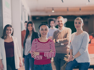 Obraz premium Beautiful Hispanic or modern Muslim businesswoman looking at camera and smiling coworkers diverse team in modern open space office in background