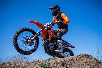 Close up of motocross rider taking off from a jump.