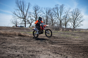 Dirt biker takes off spewing lots of dirt and debris.