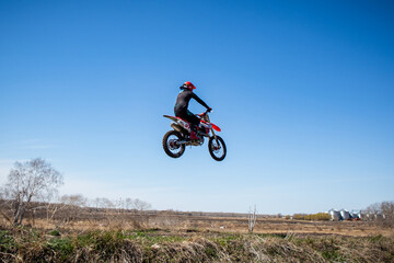 Fototapeta na wymiar Motocross rider jumps his dirt bike on a racetrack. 