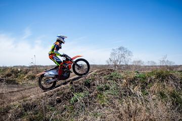 Motocross rider about to take off from a jump.