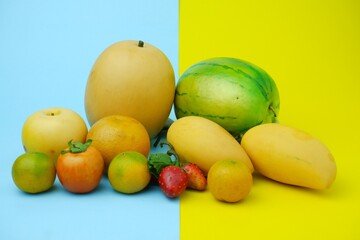 Plastic fruit on blue background with yellow color. Fake fruit, fruit model.
