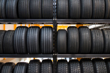 A new tire is placed on the tire storage rack in the car service center. Be prepared for vehicles that need to change tires. - obrazy, fototapety, plakaty