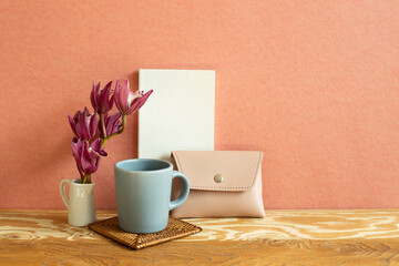 Notebook, mug cup, flower, wallet on wooden desk. red background. Work and study place