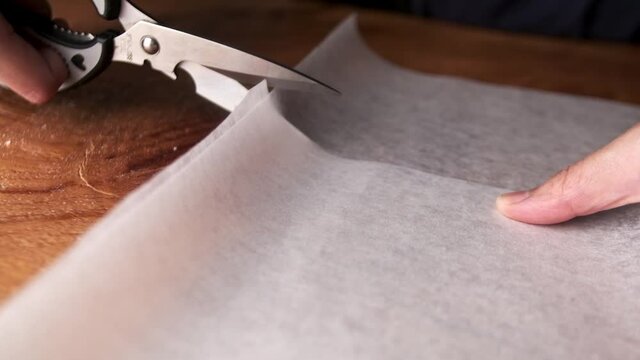 slow motion of cutting tracing paper using scissors close up macro shot