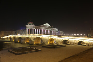 Fototapeta na wymiar Stone Bridge, behind the Archeology Museum at night in Skopje, Macedonia. Stone Bridge is considered a symbol of Skopje.