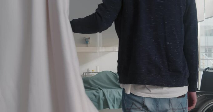 Husband in safety mask visiting pregnant woman in ward at hospital