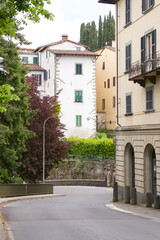 Fototapeta na wymiar A street in the medieval town of Barga. Old houses in a thousand-year-old city. Spring in an Italian town in Tuscany. Old houses along the road with retaining walls.