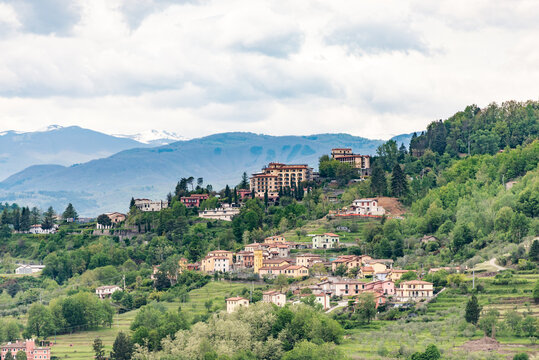 View from the observation deck at the top of the city in the mountains. Gardens and vegetable gardens with houses on the slopes of the Tuscan mountains near the town of Barga.