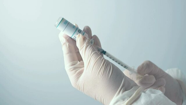Manos de un profesional preparando una vacuna contra el covid-19