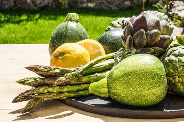 Healthy vegetable eating concept: A plate with fresh green and organic artichokes, asparagus,...