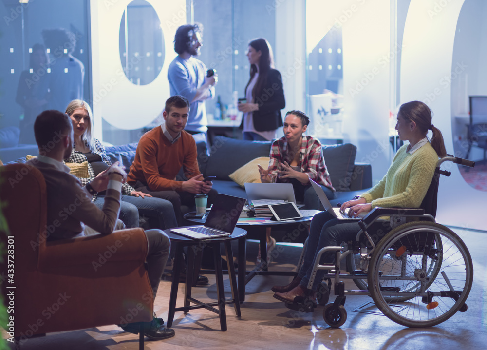 Wall mural handicapperd businesswoman in a wheelchair on meeting with her diverse business team brainstorming a