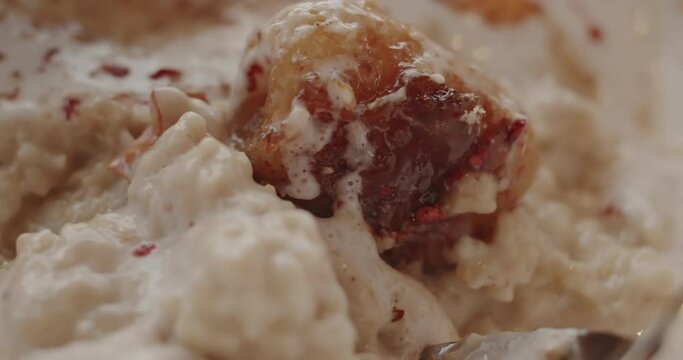 Delicate porridge with coconut mousse, freeze-dried raspberries and bananas fried in caramel, stir with a tablespoon