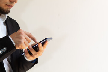 hands of a businessman in a black suit using a smartphone