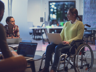 Handicapperd businesswoman in a wheelchair on meeting with her diverse business team brainstorming...