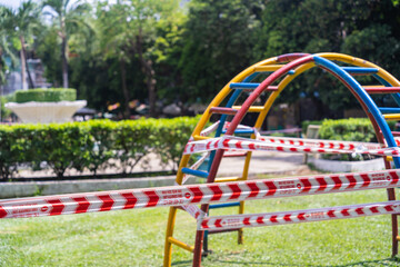 Fototapeta premium Park kids and children playground for game and activity empty and closed for Coronavirus or Covid19. And strips with word 