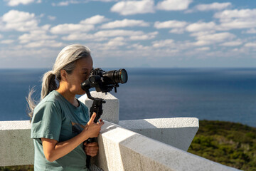 奄美大島の蒲生崎展望台で動画撮影をする女性フォトグラファー