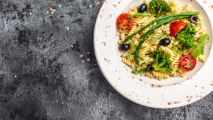 Greek Salad with pasta. Bowl of fusili pasta salad with fresh vegetables. Long banner format, top view
