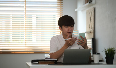 Business woman reading information on paperwork and using laptop working on desk.