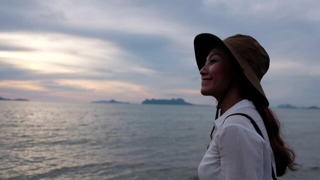 A young asian woman watching a beautiful sea view before sunset