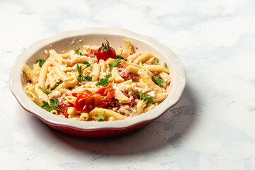 Trending viral Feta pasta recipe with tomatoes, cheese, garlic and herbs in a casserole dish. cooking recipe ingredients, place for text, top view