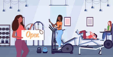 female fitness trainer holding open sign board coronavirus quarantine is ending victory over covid-19