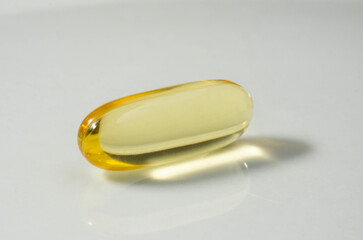 Cod liver oil capsule pill. Close up fish oil pills on the white plate