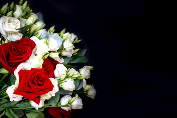 Beautiful bouquet of red roses and white eustoma on a black background. Top view, copy space, romantic card for wedding, birthday or valentine's day