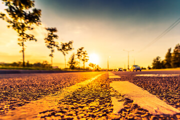 Sunset in the country, the approaching car on the highway. Wide angle view of the level of the dividing line