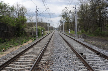 Fototapeta premium Railroad tracks for trains with steel rails and gravel creating straight perspective lines till horizon