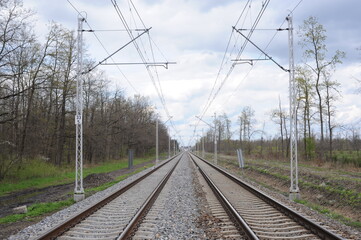 Obraz premium Railroad tracks for trains with steel rails and gravel creating straight perspective lines till horizon