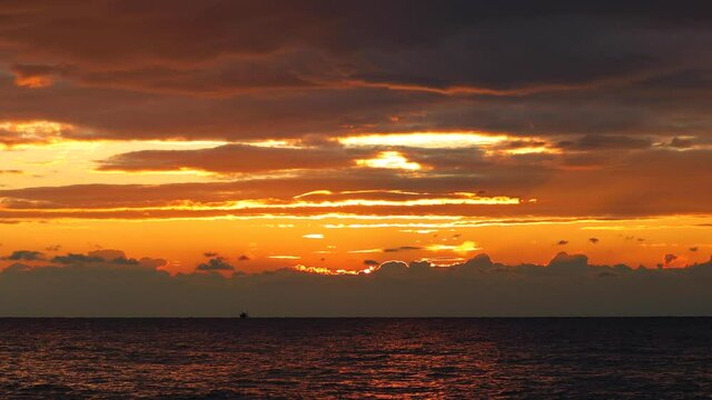 Golden ocean beach sunrise with dramatic sky clouds