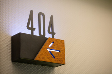 Closeup of 404 hotel room number with an arrow sign showing the direction