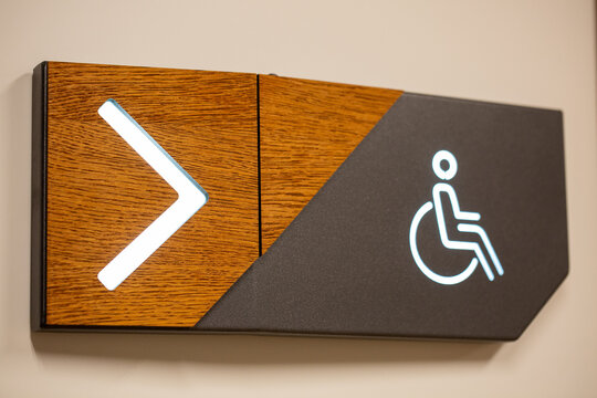 Closeup of PWD comfort room signage with an arrow sign showing the direction