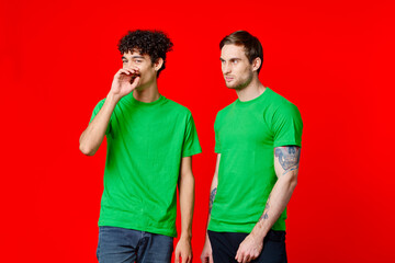 Fototapeta premium two friends in green t-shirts fun communication red background