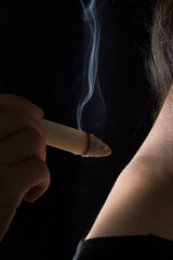 close up of hand holding moxa stick  on female neck